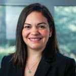 a woman in a black suit smiling at the camera