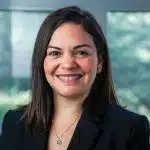 a woman in a black suit smiling at the camera